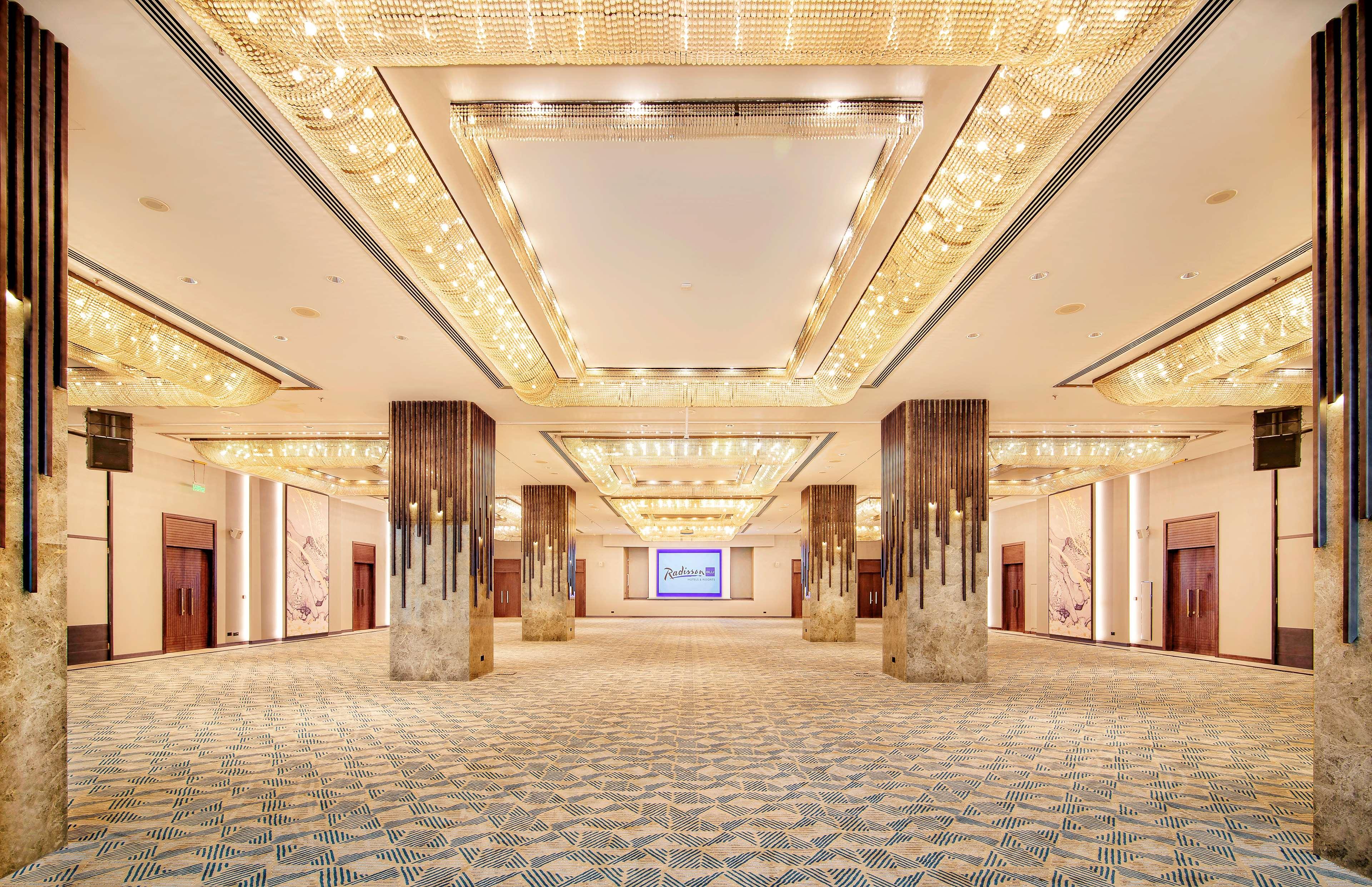 Radisson Blu Hotel & Resort, Abu Dhabi Corniche Екстериор снимка The photo depicts a spacious and elegantly designed interior hall, likely part of a conference or event venue. The ceiling features decorative lighting elements, providing a warm and luxurious ambiance. There are large pillars that frame the space, a