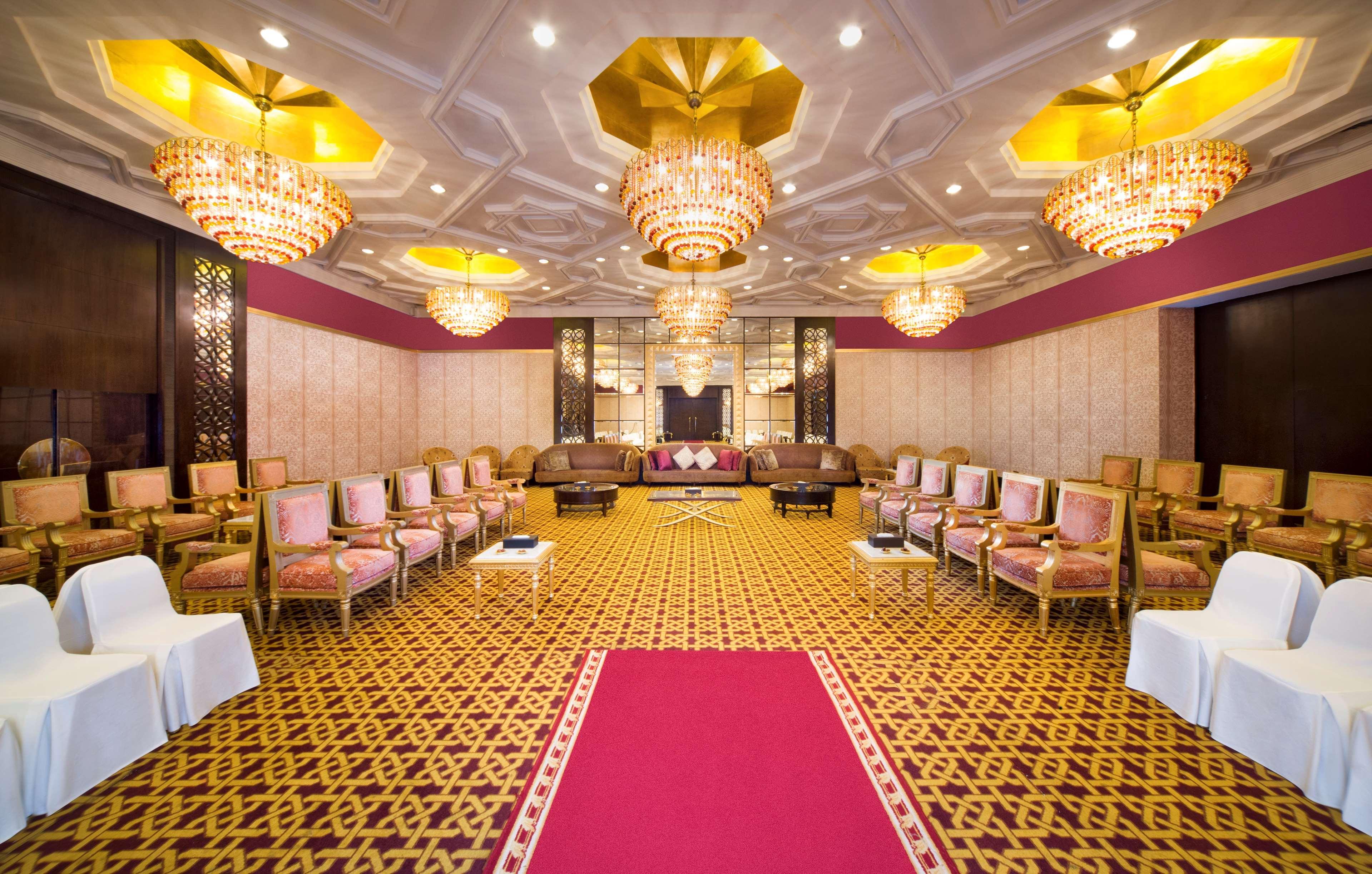 Radisson Blu Hotel & Resort, Abu Dhabi Corniche Екстериор снимка The photo shows an elegantly designed interior space, likely a banquet or conference room. The room features ornate chandeliers with golden accents hanging from the ceiling, providing ample lighting. The walls are decorated with a subtle pattern, and
