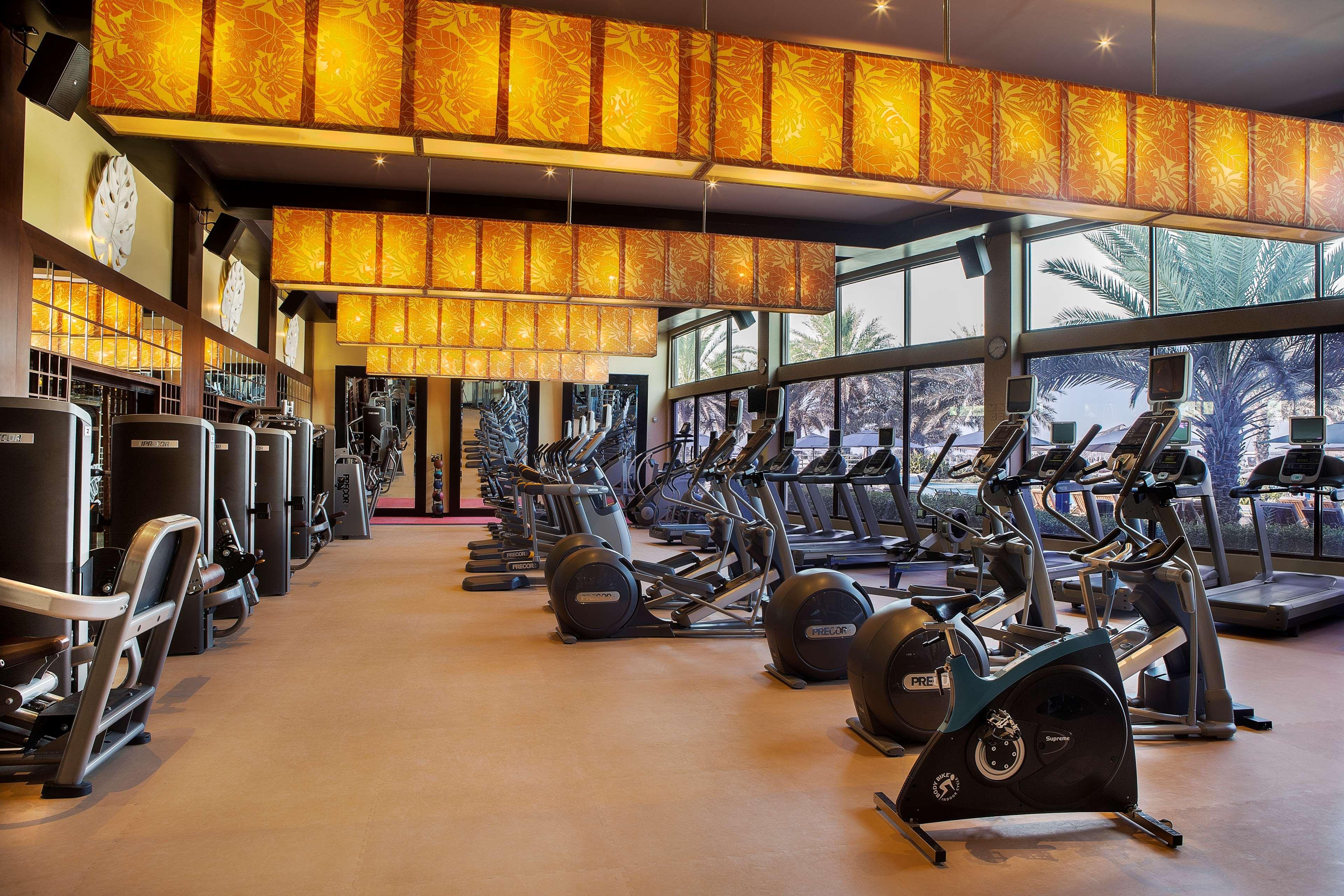Radisson Blu Hotel & Resort, Abu Dhabi Corniche Екстериор снимка The photo shows a modern gym interior with various exercise equipment. The gym features multiple cardio machines, such as treadmills and stationary bikes, arranged neatly. Large windows allow natural light to enter the space, and the walls are decora