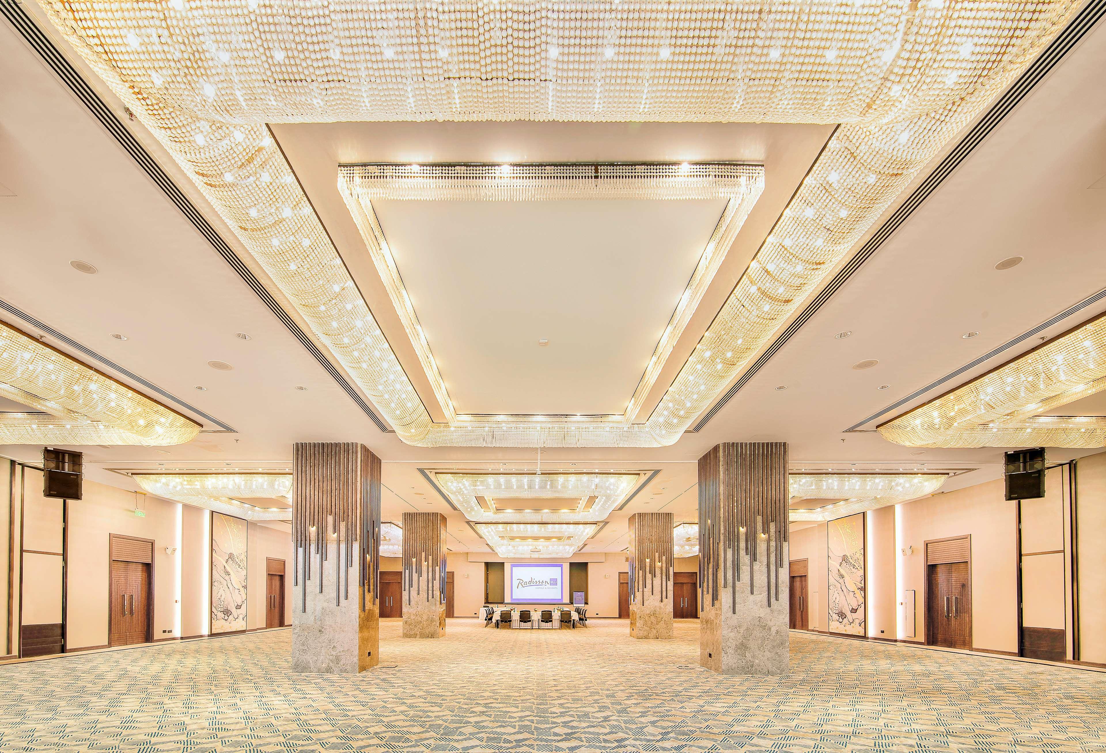 Radisson Blu Hotel & Resort, Abu Dhabi Corniche Екстериор снимка The photo shows a spacious event hall with a luxurious design. The ceiling features an elaborate arrangement of lights, creating a bright and elegant atmosphere. The walls are adorned with decorative elements, and the floor appears to be covered with